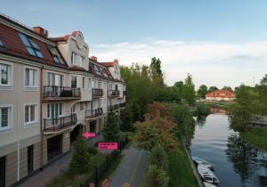 arial view of a river with buildings and a street at Apartament z dziedzińcem koło rzeki in Ełk