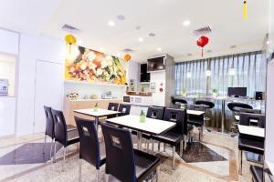 a restaurant with tables and chairs and a kitchen at Dealer Hotel in Taipei
