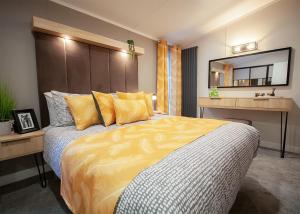 a bedroom with a large bed with yellow pillows at Sandgreen Caravan Park in Girthon