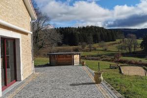 un edificio con garaje junto a un campo en Villa avec tout le confort dans le livradois forez 