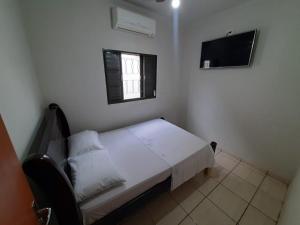 - une petite chambre avec un lit et une télévision dans l'établissement Divina Luz Casa de Temporada Olimpia, à Olímpia