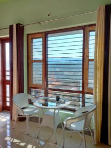 a room with a table and chairs and a large window at Laxmi Jawahar Homestay in Dehradun