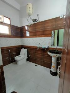 y baño con aseo y lavamanos. en Laxmi Jawahar Homestay, en Dehradun