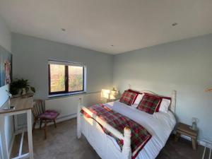 a bedroom with a bed and a desk and a window at Cosy stable conversion between Sheffield & Leeds in Pontefract