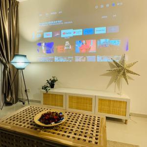 a living room with a table and a large screen at Ataraxia park condo forest city in Gelang Patah