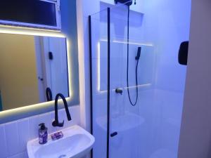 a white bathroom with a sink and a shower at Flat Atlântica Alto luxo - Posto 6 Copacabana in Rio de Janeiro