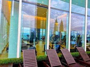 クアラルンプールにあるThe Platinum KLCC By Victoria Homeの椅子付きの客室で、市街の景色を望めます。