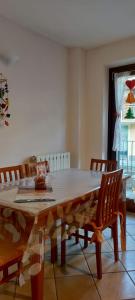 mesa de comedor con 2 sillas y ventana en NEW ENTRY - Nuova villa nel verde en Mezzana