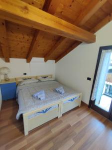 a bedroom with a bed in a room with wooden ceilings at NEW ENTRY - Nuova villa nel verde in Mezzana