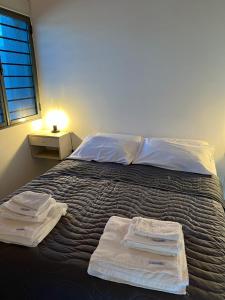 - une chambre avec un lit et des serviettes dans l'établissement Lautaro, à San Juan