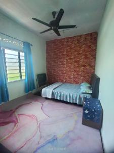 a bedroom with a bed and a brick wall at Miezzan Homestay in Kuala Selangor