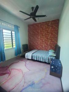 クアラ・セランゴールにあるMiezzan Homestayのベッドとレンガの壁がある寝室