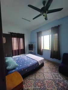 a bedroom with a bed and a ceiling fan at Miezzan Homestay in Kuala Selangor