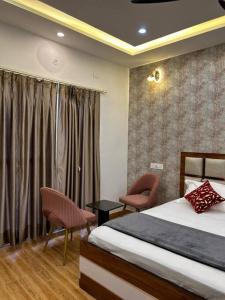 a bedroom with a bed and two chairs and a window at Apartment in Varanasi (1BHK) in Pura Raghunāth