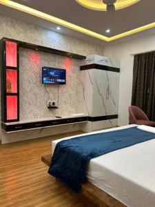 a bedroom with a bed and a tv on a wall at Apartment in Varanasi (1BHK) in Pura Raghunāth