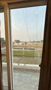 a window in a room with a view of a field at Apartment in Varanasi (1BHK) in Pura Raghunāth