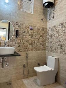a bathroom with a toilet and a sink and a mirror at Apartment in Varanasi (1BHK) in Pura Raghunāth