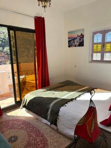 a bedroom with a bed and a large window at Chez Yahia, Au coeur de L'Ourika in Ourika