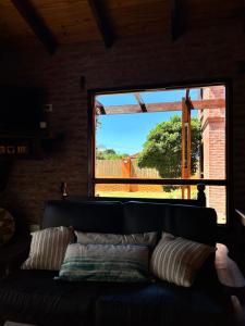 - un canapé dans le salon doté d'une grande fenêtre dans l'établissement Casa Fortaleza Hostel, à San Bernardo