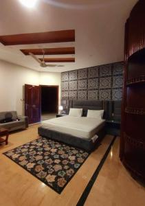 a bedroom with a large bed and a rug at Madcrew Lodge in Islamabad