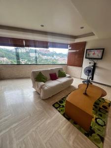 Río de Oro في كاراكاس: غرفة معيشة مع أريكة بيضاء وطاولة