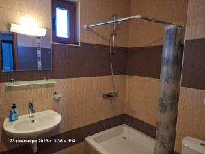 La salle de bains est pourvue d'un lavabo et d'une douche. dans l'établissement Guest House Ivanini Houses, à Tryavna