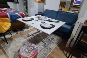 einen weißen Tisch mit Tellern und Gläsern und ein Sofa in der Unterkunft luxury & comfy city break studio in London