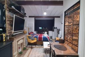 Schlafzimmer mit einem Bett, einem TV und einem Tisch in der Unterkunft luxury & comfy city break studio in London