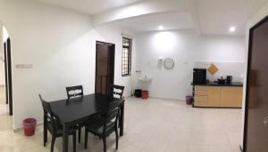 a dining room with a black table and chairs at 4 Bedrooms Semi D Muslim Homestay by Mr Homestay Kulim in Kulim