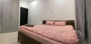 a bed with a pink comforter in a bedroom at 4 Bedrooms Semi D Homestay by Mr Homestay in Kulim +1 photo