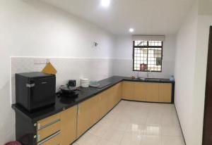 a kitchen with a black counter top in a room at 4 Bedrooms Semi D Muslim Homestay by Mr Homestay Kulim in Kulim