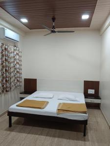 a bed in a room with a ceiling at Samraj Lodge in Akalkot