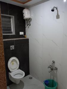 a small bathroom with a toilet and a shower at Samraj Lodge in Akalkot