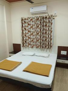 a hospital room with a bed with two towels on it at Samraj Lodge in Akalkot