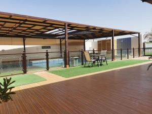 a patio with a table and chairs on a deck at alshahad chalet in Bārsit