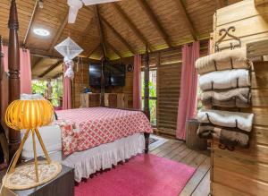 ein Schlafzimmer mit einem Bett in einem Holzhaus in der Unterkunft Adorable, Cosy Wooden Bauhinia Cottage in Roseau