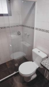 a bathroom with a white toilet and a shower at Pousada Kybalion in Búzios