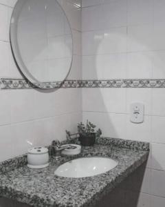 La salle de bains est pourvue d'un lavabo et d'un miroir. dans l'établissement Pousada Kybalion, à Búzios