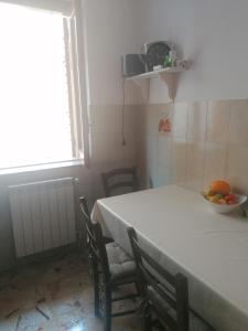 una mesa con sillas y un bol de fruta en ella en Stanza con terrazza, en Calamonaci