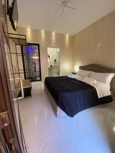 una camera da letto con un grande letto con un piumone nero di LE CAMERE Luxury Rooms SIRACUSA a Siracusa