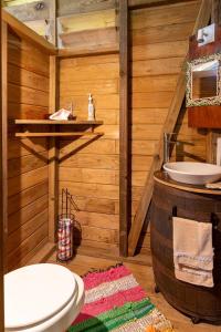 ein Badezimmer mit einem WC, einem Waschbecken und einem Fass in der Unterkunft Adorable, Cosy Wooden Bauhinia Cottage in Roseau