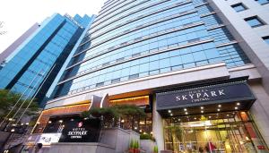 uma loja em frente a um arranha-céus numa cidade em Hotel Skypark Central Myeongdong em Seul