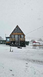 a building in a field covered in snow at mood villa Kazbegi in Stepantsminda