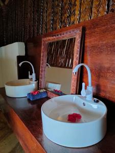 a bathroom with a sink and a mirror on a counter at Mtende Beach Bungalow océan view in Mtende