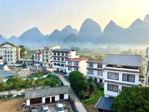 vistas a una ciudad con montañas en el fondo en Yangshuo Xiao Long River Hotel en Yangshuo