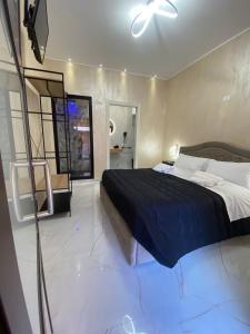 LE CAMERE Luxury Rooms SIRACUSA في سيراكوزا: غرفة نوم فيها سرير وتلفزيون