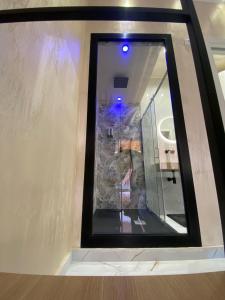 LE CAMERE Luxury Rooms SIRACUSA في سيراكوزا: مرآة في الحمام مع جدار حجري