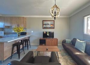sala de estar con sofá y mesa en The Acorn @ Skyfall Country Estate en Polokwane