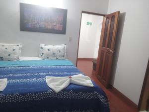 Un dormitorio con una cama con una pajarita. en Hostal central, en Villa de Leyva