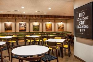 uma sala de jantar com mesas e cadeiras e um quadro-negro em Fairfield Inn & Suites by Marriott Boston Walpole em Walpole